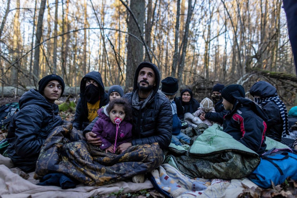 Members of a Kurdish family from Dohuk in Iraq are seen in a forest near the Polish-Belarus border while waiting for the border guard patrol, near Narewka, Poland, Nov. 9, 2021. (