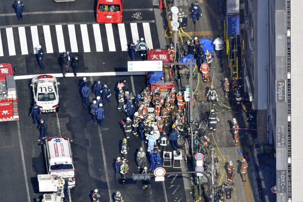 Policemen and firefighters gather near a building where a fire broke out in Osaka, western Japan, Dec. 17, 2021. (File photo/Kyodo News via AP)