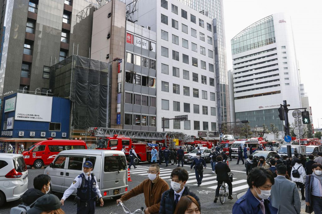 Fire engines park near a building, center in the background, where a fire broke out in Osaka, western Japan Friday, Dec. 17, 2021. (File photo/Kyodo News via AP)