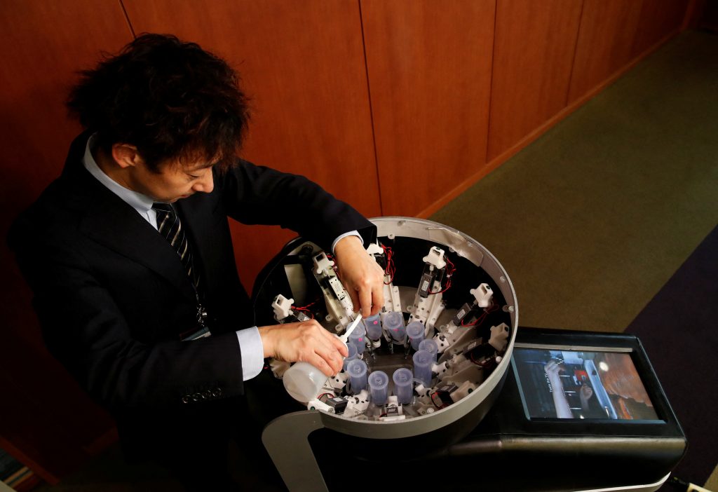 Meiji University professor Homei Miyashita fills flavour canisters as he demonstrates Taste the TV (TTTV), a prototype lickable TV screen that can imitate the flavours of various foods, at the university in Tokyo, Japan, December 22, 2021. Picture taken on December 22, 2021. (Reuters)