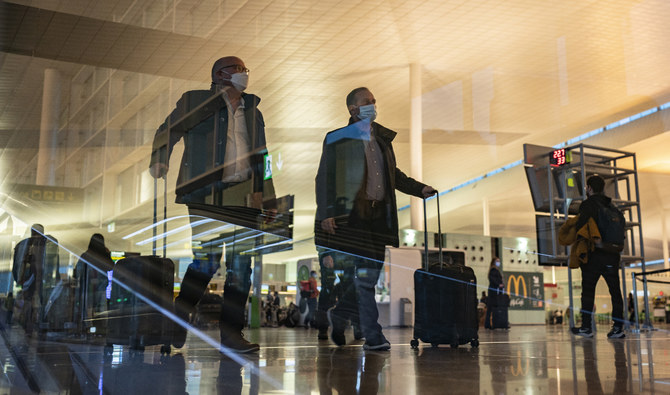 Passengers walk inside a terminal of the Barcelona Airport, Wednesday, Dec. 1, 2021. (AP)