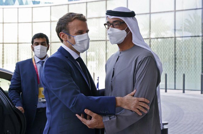 French President Emmanuel Macron, left, is greeted by Abu Dhabi's Crown Prince Mohammed bin Zayed Al-Nahyan at the Dubai Expo on the first day of his Gulf tour on December 3, 2021. (AFP)