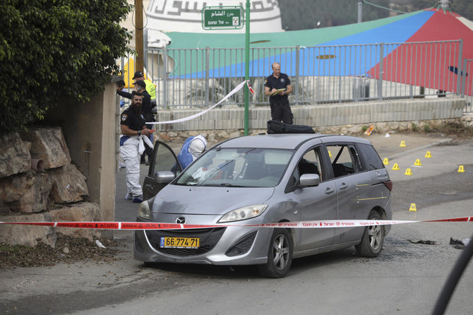 Police examine a car in Umm el-Fahm, Israel, Friday, Dec. 3, 2021, after a man was shot dead by Israeli police in a car-ramming incident, following a night of intense violence in the Arab populated Israeli town. (AP)