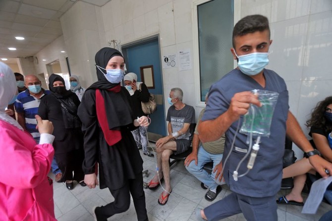 A medic assists a patient at Rafic Hariri University Hospital in Lebanon, whose lawmakers on Tuesday ratified a law fining the unvaccinated, who spread covid19, 250,000 Lebanese pounds. (STR/AFP via Getty Images)