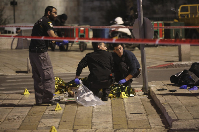 Israeli police examine the body of a Palestinian attacker who was killed by Israeli forces after stabbing an ultra-Orthodox Jewish man near Damascus Gate next to the Old City of Jerusalem. (AP)