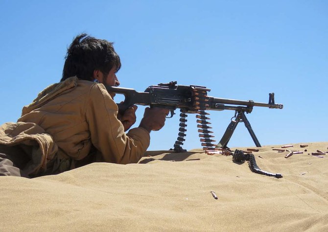 A Yemeni pro-government fighter takes aim from his position during fighting with Houthi rebels on the al-Jawba frontline south of Marib, the last remaining government stronghold in northern Yemen, on December 7, 2021. (Photo by AFP)