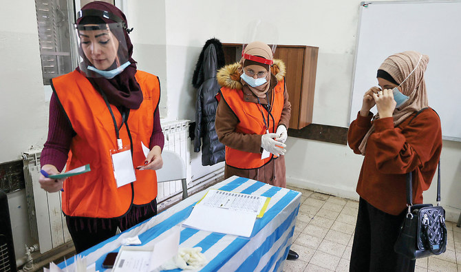 A woman registers to vote at a polling station during Saturday’s municipal elections in the village of Dura Al-Qar, east of the city of Ramallah. (AFP)