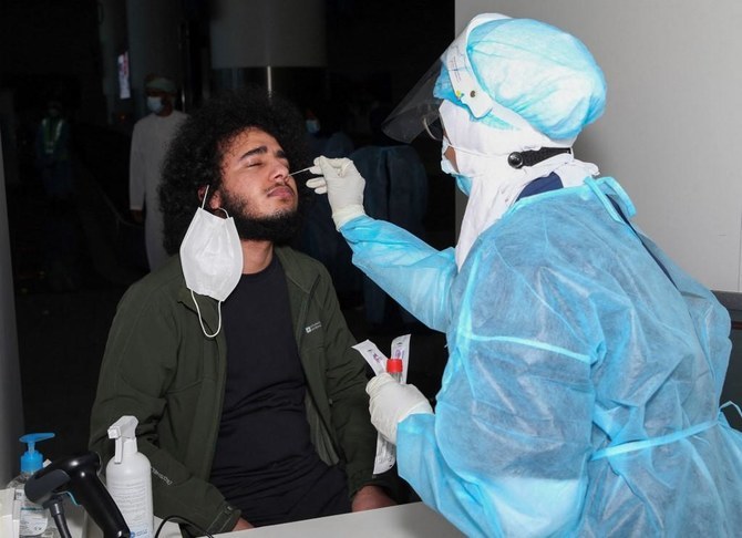 A medical worker collects a swab sample from a passenger for a RT-PCR Coronavirus test at the Muscat international airport in the Omani capital on Oct. 1, 2020. (File/AFP)