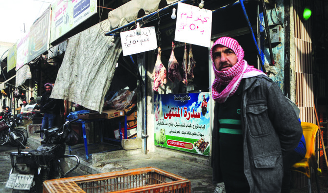 A man stands next to a butcher shop in the main market of the rebel-held city of Al-Bab in Syria’s northern Aleppo province on the border with Turkey. (AFP)