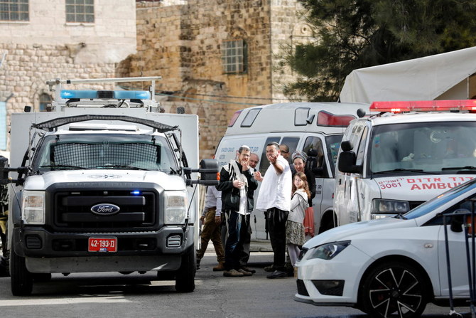 An injured Israeli settler talks to medics near the scene of a security incident in Hebron, in the Israeli-occupied West Bank December 18, 2021. (Reuters)