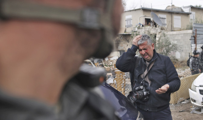 Associated Press photographer Mahmoud Illean reacts after being attacked by Israeli police while covering a demonstration in the east Jerusalem neighborhood of Sheikh Jarrah, Friday, Dec. 17, 2021. (AP)