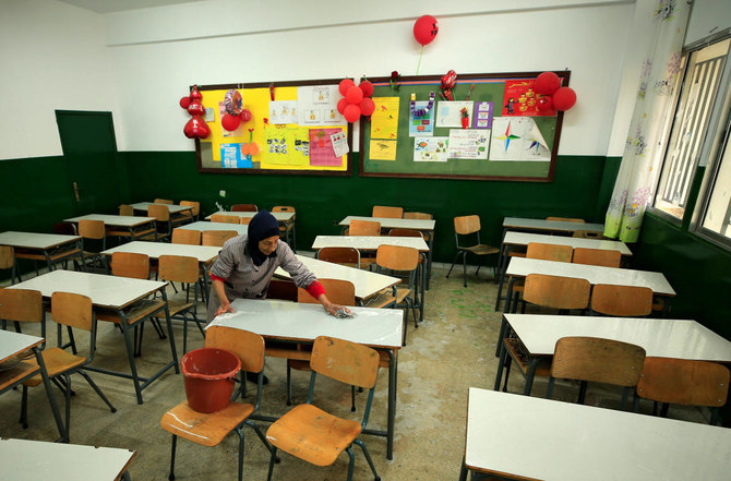 A worker cleans classroom desks in a Lebanese school in Febraury 2020. World Bank on Thursday said it agreed with its partners to repurpose $37 million in funds to help Lebanon's public school teachers survive a crushing economic crisis. (Reuters)