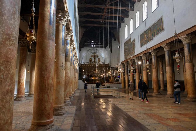 The faithful visit the Church of the Nativity in the city of Bethlehem in the occupied West Bank on December 21, 2021. (AFP)