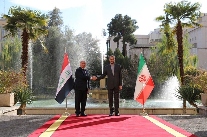 Iranian Foreign Minister Hossein Amir-Abdollahian greets his Iraqi counterpart Fuad Hussein in the capital Tehran on Thursday. (AFP)