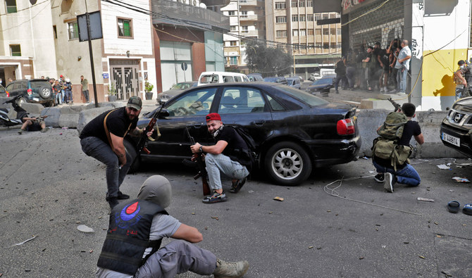 Fighters from Shiite Hezbollah and Amal movements take aim during clashes in the area of Tayouneh, in the southern suburb of the capital Beirut, on October 14, 2021. (AFP)