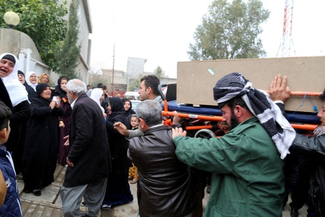 Iraqi men carry a coffin belonging to one of the victims of a Kurdish family which drowned on a boat headed to the Greek island of Leros. (File/AFP)