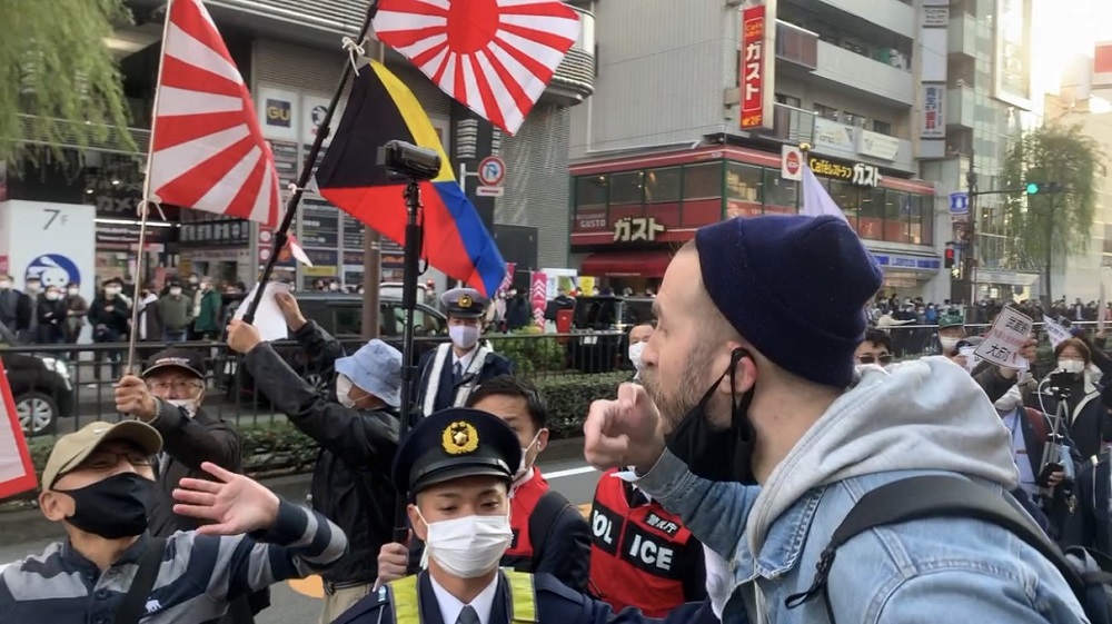 A foreign resident in Musashino city expresses displeasure to a Japanese participant in a demonstration held recently against voting rights to foreigners. (ANJ)