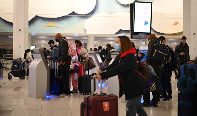 Travelers wear masks at LaGuardia International Airport on November 30, 2021 in New York, New York as concern grows worldwide over Omicron, the newest Covid-19 variant. (AFP)