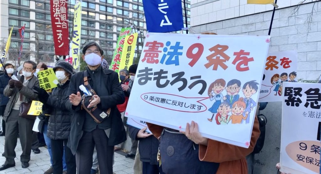 Demonstrators holding placards and banners with slogans such as 