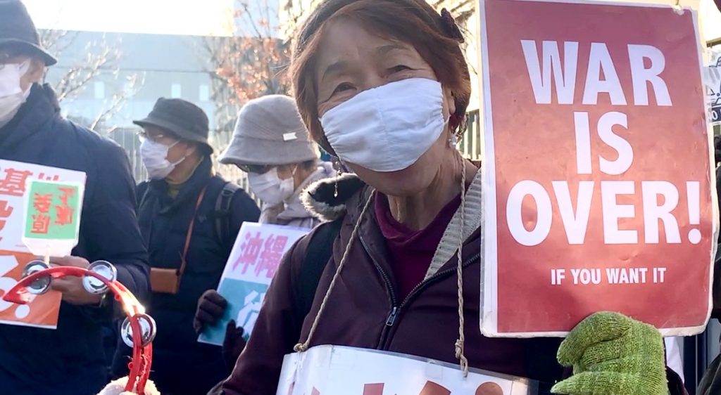 Demonstrators holding placards and banners with slogans such as 