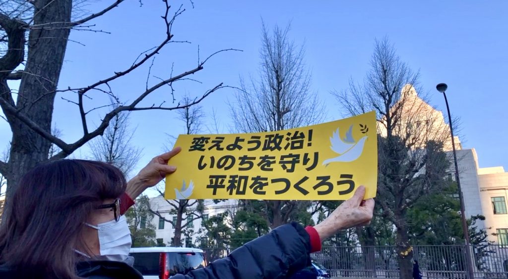 Demonstrators holding placards and banners with slogans such as 