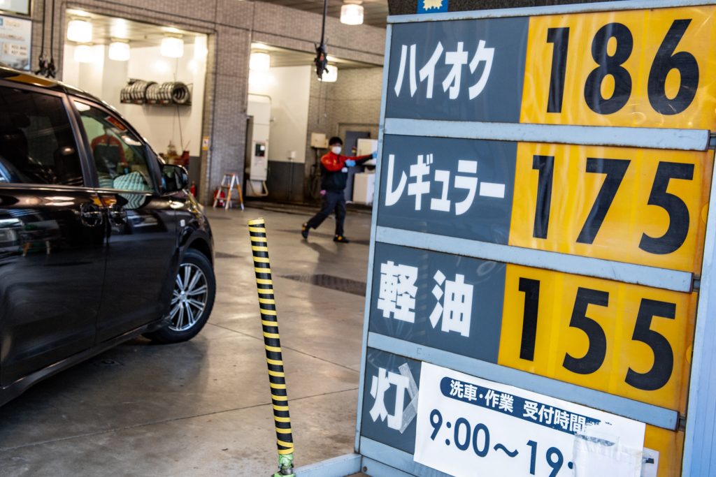 The price of gasoline is seen on a board at a gas station in Chuo district of Tokyo on January 18, 2022. (AFP)