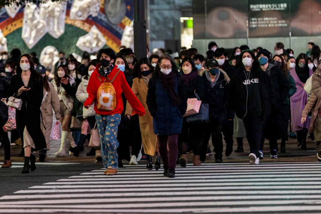 People wearing face masks walk at Shibuya crossing in Tokyo. (AFP)