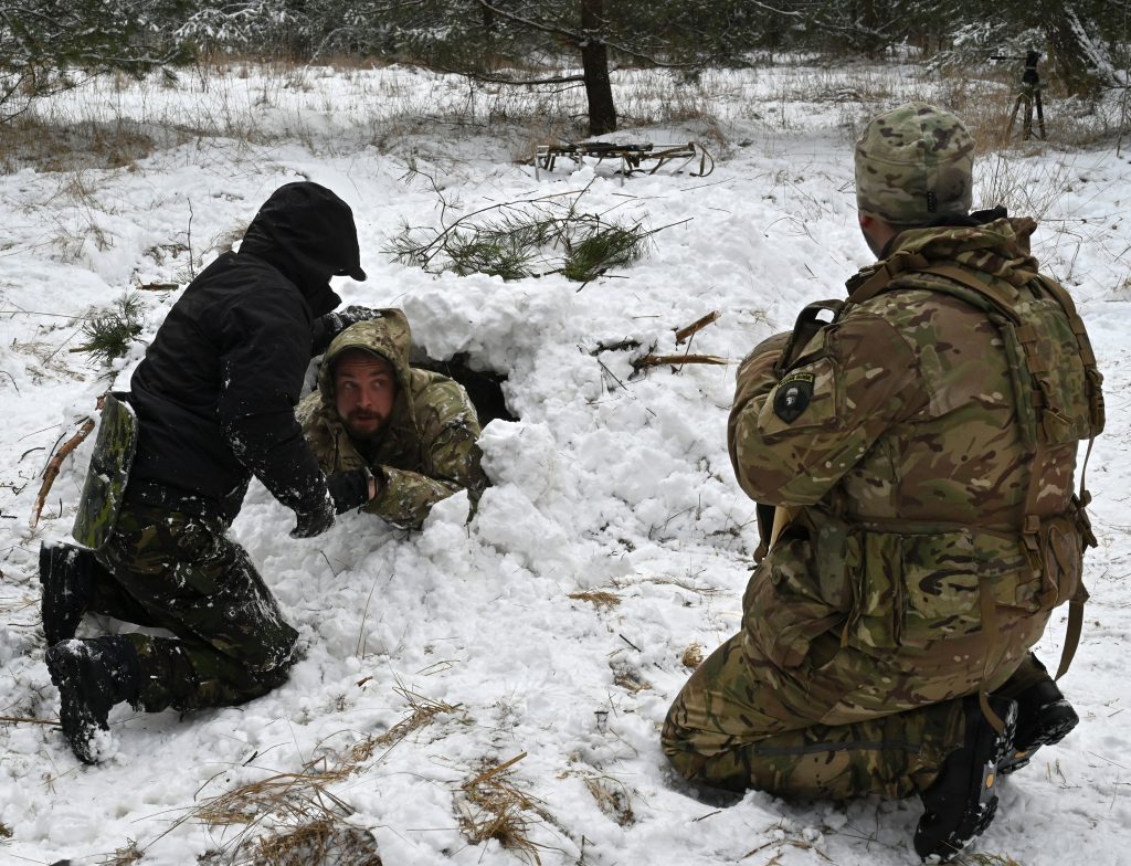 Ukrainian civilians learn to build a shelter out of the deep snow as part of a crash course in survival techniques, in a forest on the outskirts of Kyiv, on January 30, 2022. (AFP)