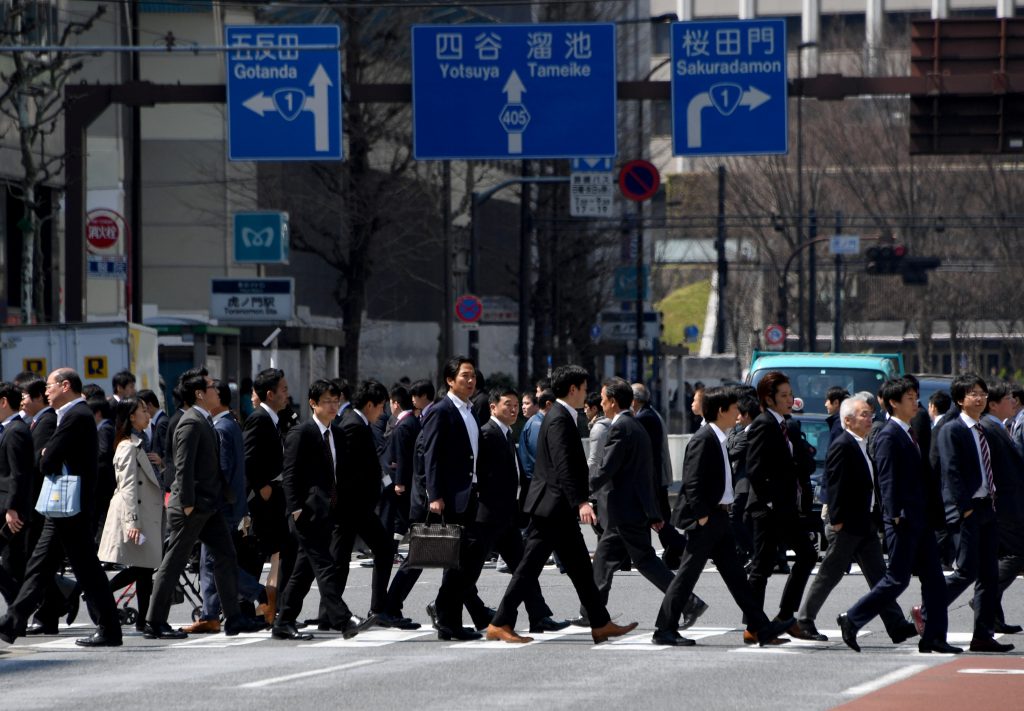 White-collar workers walk on a crosswalk in Tokyo. (AFP)