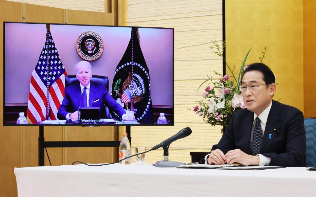  Prime Minister Fumio Kishida, right, sitting in a room of the prime minister's official residence in Tokyo, Friday, Jan. 21, 2022, talks in a virtual meeting with U.S. President Joe Biden, shown in the monitor. (File photo/AP)