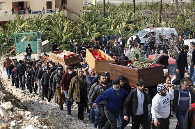Mourners carry the coffins of a Syrian mother and her three children who died in their sleep in Al-Wasta village near Sidon, Lebanon, Sunday, Jan. 2, 2022. (AP)