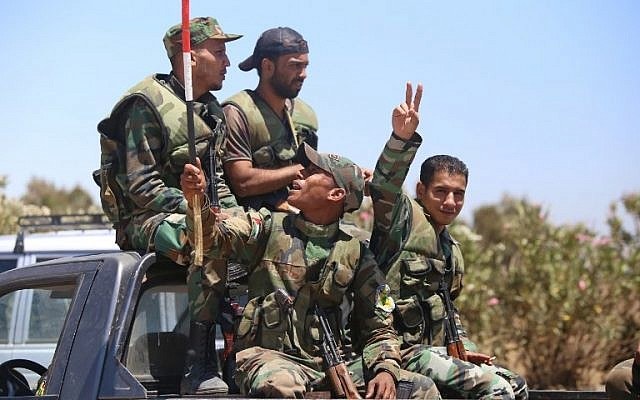 A Syrian soldier gestures as he rides in a car in the town of Quneitra in the Syrian Golan Heights on July 27, 2018. (AFP)