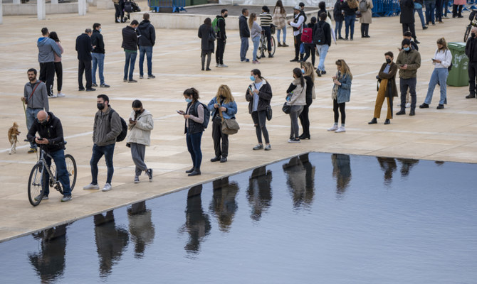 People, some wearing protective face masks, line up for PCR and Rapid Antigen COVID-19 coronavirus tests in Tel Aviv, Israel, Tuesday, Jan. 4, 2022. (AP)