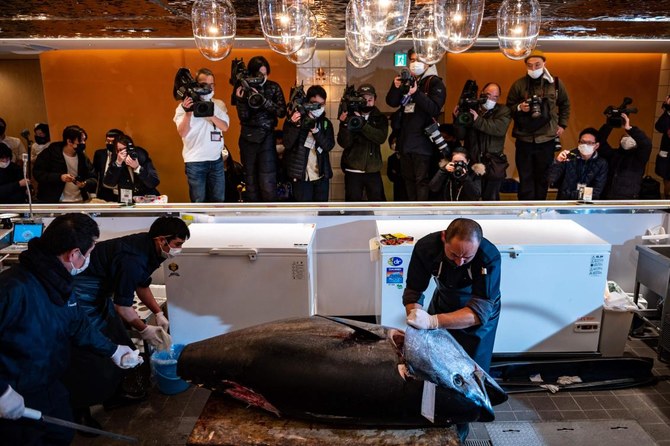 Staff members cut a tuna which was bought jointly by Michelin-starred sushi restaurant operator Onodera Group and wholesaler Yamayuki for $145,290 at the Toyosu fish market’s New Year auction. (AFP)