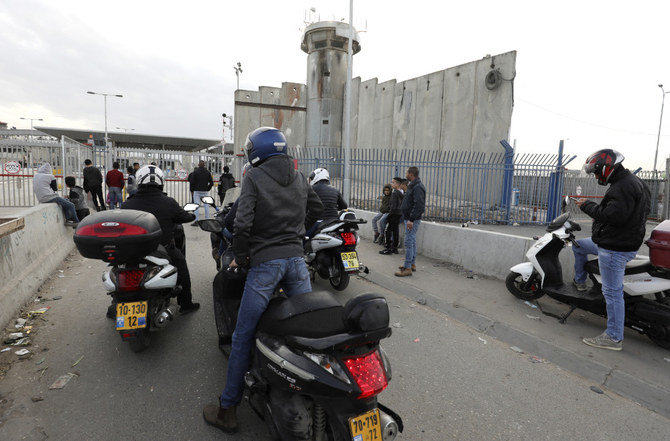 Palestinian cyclists wait at the temporarily closed Qalandia checkpoint on the crossing between the West Bank city of Ramallah and Israeli-occupied east Jerusalemon on December 7, 2020. (AFP)