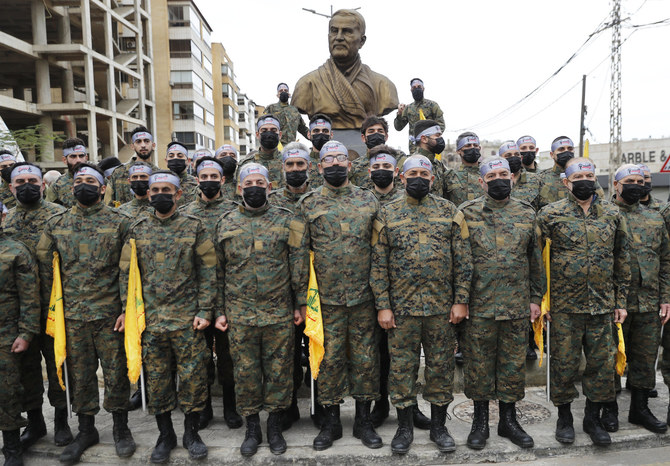 Hezbollah fighters stand in front of a statue of Iranian general Qassem Soleimani in Beirut, Lebanon, during a ceremony to mark the second anniversary of his assassination two years ago. (AP Photo/Hussein Malla)