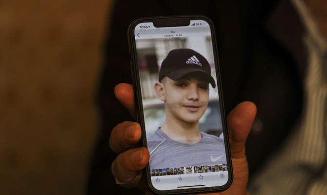 Moammar Nakhleh, the father of 17 year-old Palestinian prisoner Amal, shows a photograph of his son on his telephone, in Jalazun refugee camp, near the occupied West Bank city of Ramallah, on January 8, 2022. (AFP)