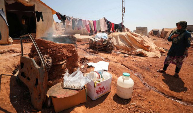 A displaced Syrian woman, stands next to her tent at a camp for displaced Syrians from Idlib and Aleppo provinces, near the town of Maaret Misrin in Idlib province on July 11, 2020. (AFP/File)