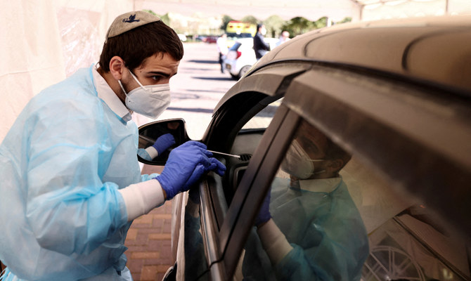 Medical staff carry out tests for the coronavirus disease (COVID-19) at a drive-through site as Israel faces a surge in Omicron variant infections, in Jerusalem, January 10, 2022. (Reuters)