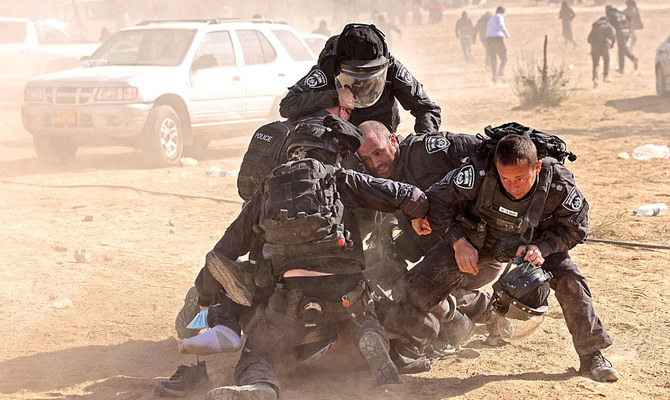 Israeli police wrestle down a man during a Bedouin protest in the southern Israeli village of Sawe Al-Atrash in the Negev Desert. The demo was against a controversial afforestation project. (AFP)