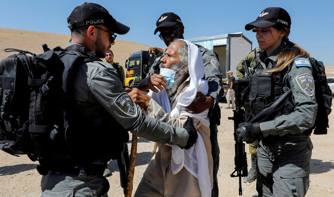 Palestinian Suleiman Al-Hathalin scuffles with Israeli border police members as Israeli forces confiscate a healthcare clinic in Yatta, in the Israeli-occupied West Bank on July 12, 2021. (Reuters)