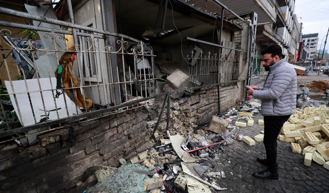 An Iraqi man checks the scene of an explosion outside Kurdish Cihan Bank in the Karrada district of Iraq's capital Baghdad on January 17, 2022. (AFP)