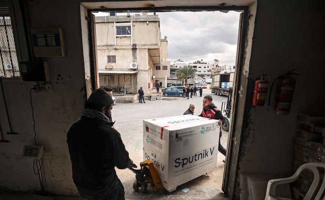 A Palestinian laborer unloads a box of the Sputnik V vaccine, donated by the UAE, at a cold storage warehouse in Gaza City on Jan. 26, 2022. (AFP)