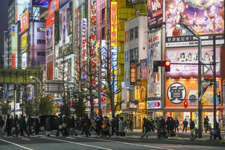 People wearing protective masks to help curb the spread of the coronavirus walk along a pedestrian crossing Wednesday, Jan. 26, 2022, in Tokyo. (AP)