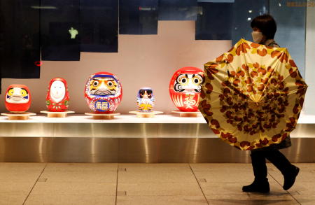 A woman wearing a protective face mask, amid the coronavirus disease (COVID-19) outbreak, walks past a display window of a department store in Tokyo, Japan, January 11, 2022. (Reuters)