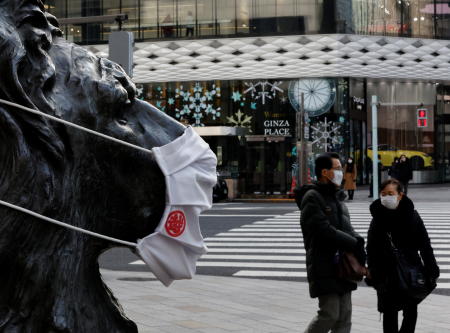 Pedestrians wearing protective masks, amid the coronavirus disease (COVID-19) outbreak, walk past a lion statue wearing a mask at a shopping district in Tokyo, Japan, January 26, 2022. (Reuters)