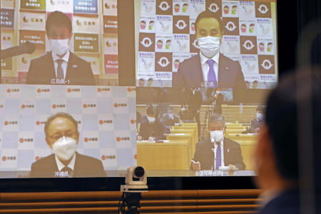 Okinawa Gov. Denny Tamaki (bottom left), Hiroshima Gov. Hidehiko Yuzaki (top left), and Yamaguchi Gov. Tsugumasa Muraoka (top right), attend an online meeting of prefectural governors, in Tokyo Thursday, Jan. 6, 2022. Japan approved new restrictions on Friday to curb a sharp rise in coronavirus cases in the three most affected southwestern regions of Okinawa, Yamaguchi and Hiroshima. (AP)