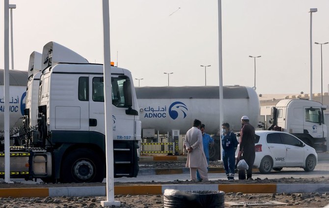 Men stand outside a storage facility of ADNOC in Abu Dhabi, on Jan. 17, 2022. Three people were killed in a suspected drone attack on ADNOC facilities on Monday. (AFP)