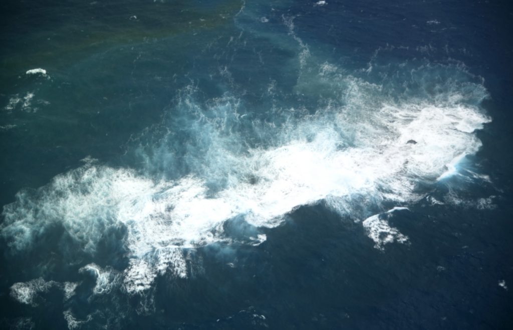 Niijima covered with white waves as photographed by Japan Coast Guard in Dec. 27, 2021. (Japan Coast Guard photo)