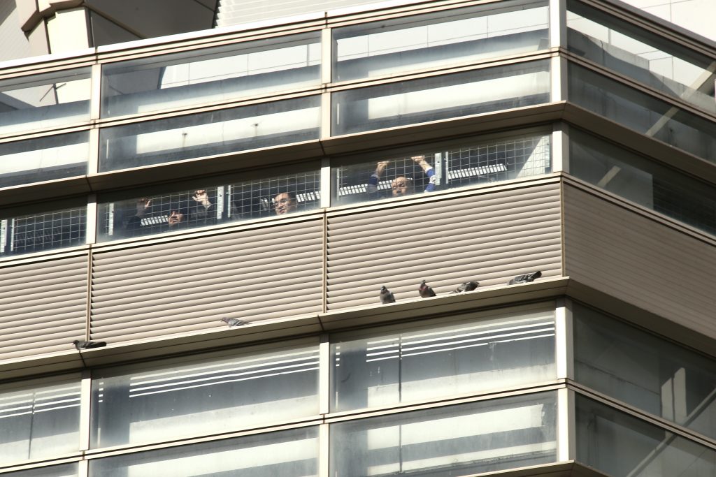 Detainees held in the a detention center inside Tokyo regional immigration building look at the demonstrators.(ANJ / Pierre Boutier)